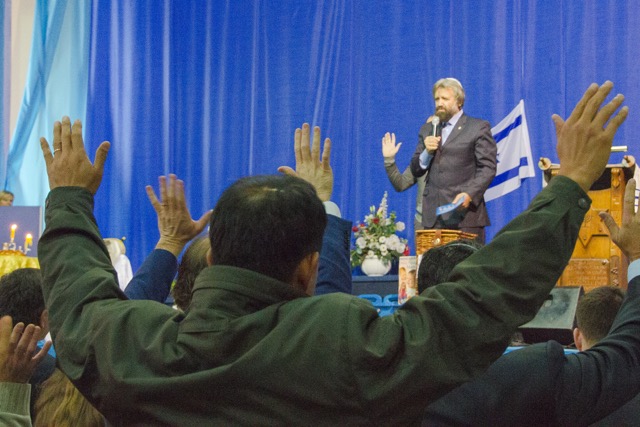 People at the Kiev Jewish Messianic Congregation raise their hands as Rabbi Boris Grisenko preaches a sermon. (Photo by Lincoln Brunner) 